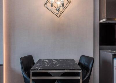 Modern dining space with geometric pendant lighting and black marble table