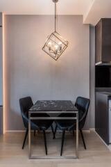 Modern dining space with geometric pendant lighting and black marble table