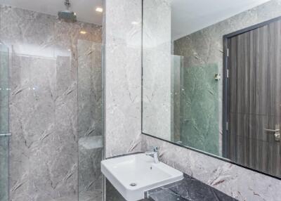 Modern bathroom with a sink, large mirror, and glass shower enclosure