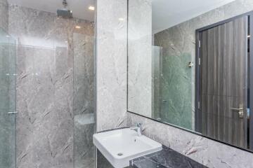 Modern bathroom with a sink, large mirror, and glass shower enclosure