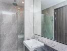 Modern bathroom with a sink, large mirror, and glass shower enclosure