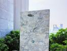 Luxurious outdoor shower area with marble finish and greenery