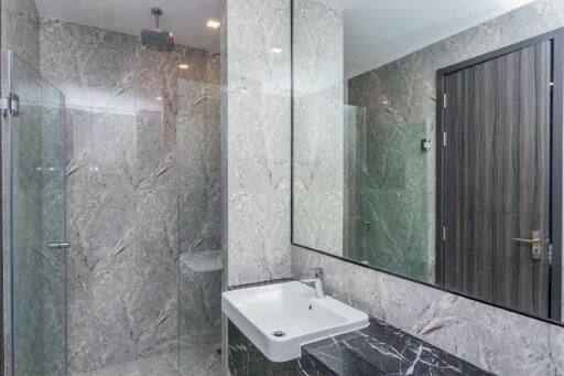 Modern bathroom with marble walls and a large mirror