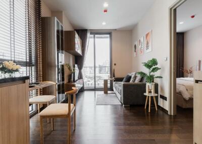 Modern living area with large windows, open layout, and adjacent bedroom