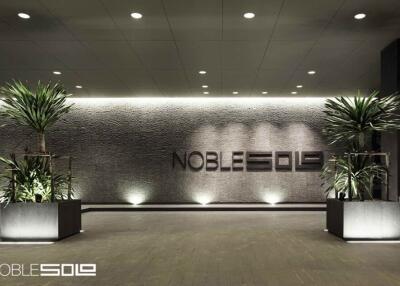 Modern building entrance with decorative plants and Noble 509 sign