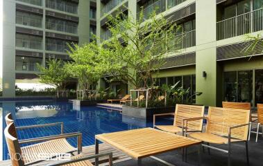 modern apartment outdoor swimming pool with seating area and greenery