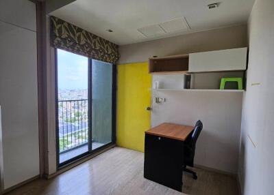 Simple bedroom with a desk, storage shelves, and a large window