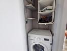 Compact laundry area with a washer and storage shelving