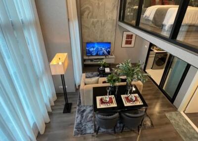 Modern living room with a dining area and a loft bedroom