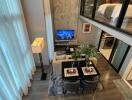 Modern living room with a dining area and a loft bedroom