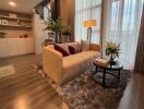 Modern living room with a beige sofa, coffee table, and large windows