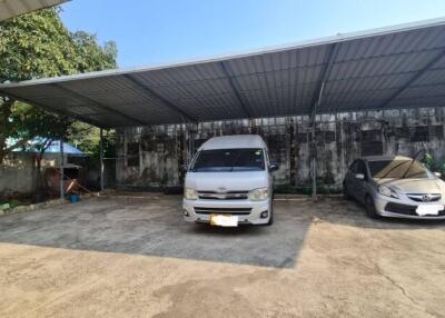 Outdoor parking area with covered spaces and vehicles