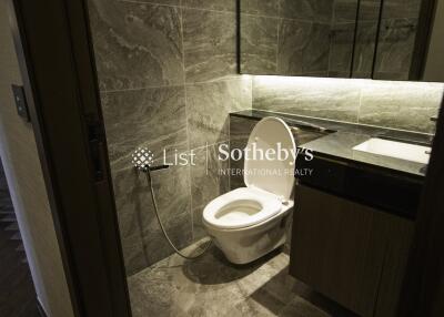 Modern bathroom with toilet and sleek dark grey tiles