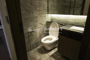 Modern bathroom with toilet and sleek dark grey tiles