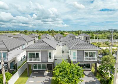 Aerial view of modern suburban houses with grey roofs and green lawns