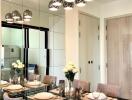 Modern dining room with glass table, beige chairs, and ceiling pendant lights