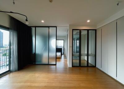 Spacious bedroom with wooden flooring and large windows