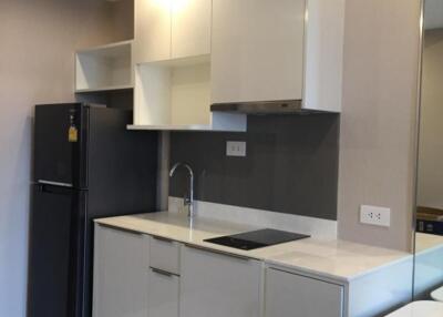 Modern kitchen with white cabinets and black refrigerator