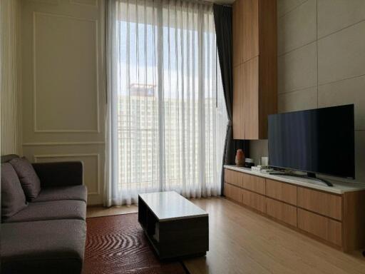 Modern living room with a large window, sofa, and TV