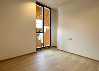 Spacious empty bedroom with wooden floor and large window