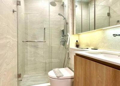 Modern bathroom with glass shower enclosure and wooden cabinets