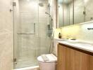 Modern bathroom with glass shower enclosure and wooden cabinets