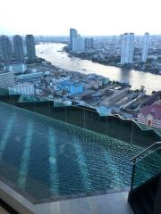 Rooftop view with infinity pool overlooking a city skyline and river