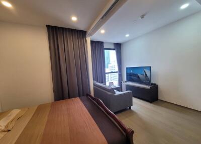 Spacious bedroom with a large bed, comfortable seating area, and a TV.