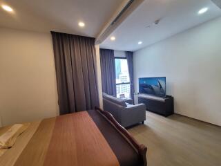 Spacious bedroom with a large bed, comfortable seating area, and a TV.