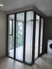 Modern laundry area with floor-to-ceiling glass enclosure and a washing machine