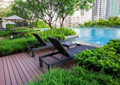 Outdoor pool area with lounge chairs and greenery