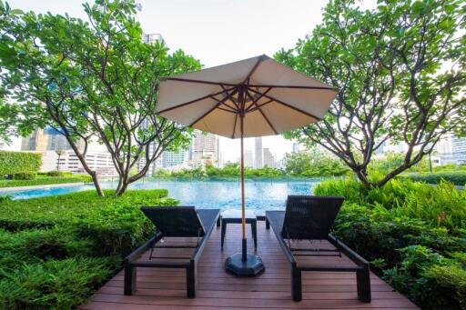 Swimming pool with deck chairs and umbrella