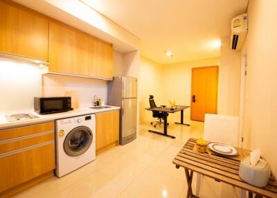 Modern kitchen with light wooden cabinets and dining area