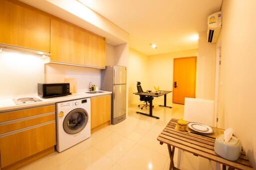 Modern kitchen with light wooden cabinets and dining area