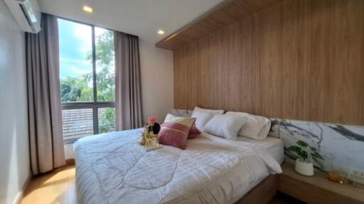 Modern bedroom with large window and wooden accents