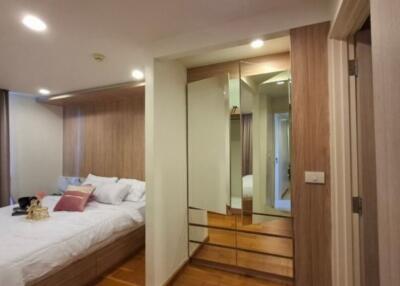 Modern bedroom with mirrored closet and wooden flooring