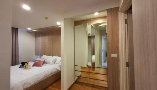 Modern bedroom with mirrored closet and wooden flooring