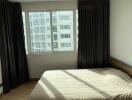 Modern bedroom with large windows and natural light