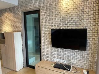 Living room with modern TV setup and textured wall