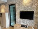 Living room with modern TV setup and textured wall