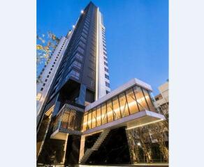 Modern high-rise building with glass facade and evening lights