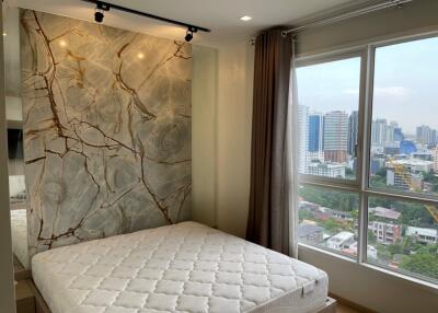 Bedroom with large window and city view