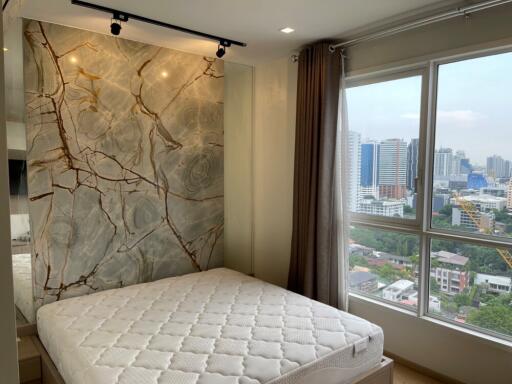 Bedroom with large window and city view