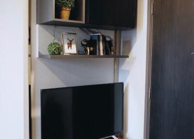 Modern living room corner with TV and shelving