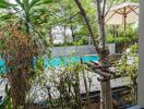 View of pool and garden area from covered patio