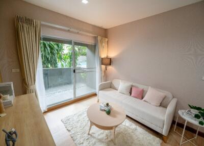 Cozy living room with a sofa, coffee table, and balcony access