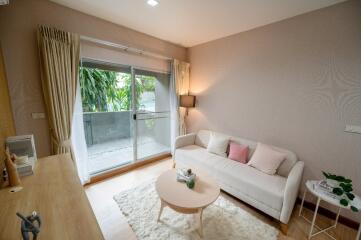 Cozy living room with a sofa, coffee table, and balcony access