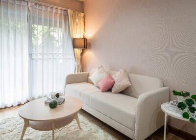 Cozy living room with a sofa, coffee table, and large window