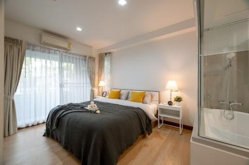 Well-lit bedroom with large windows and modern decor