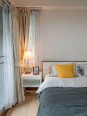 Bedroom with bedside table, lamp and yellow pillow on bed